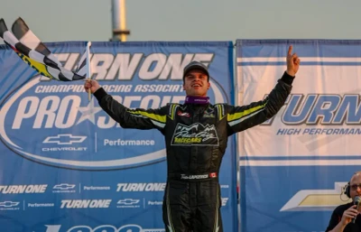 Race car driver Treyten Lapcevich waves flag at victory lane