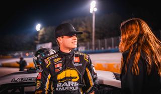 Treyten Lapcevich sits by his car speaking to a woman